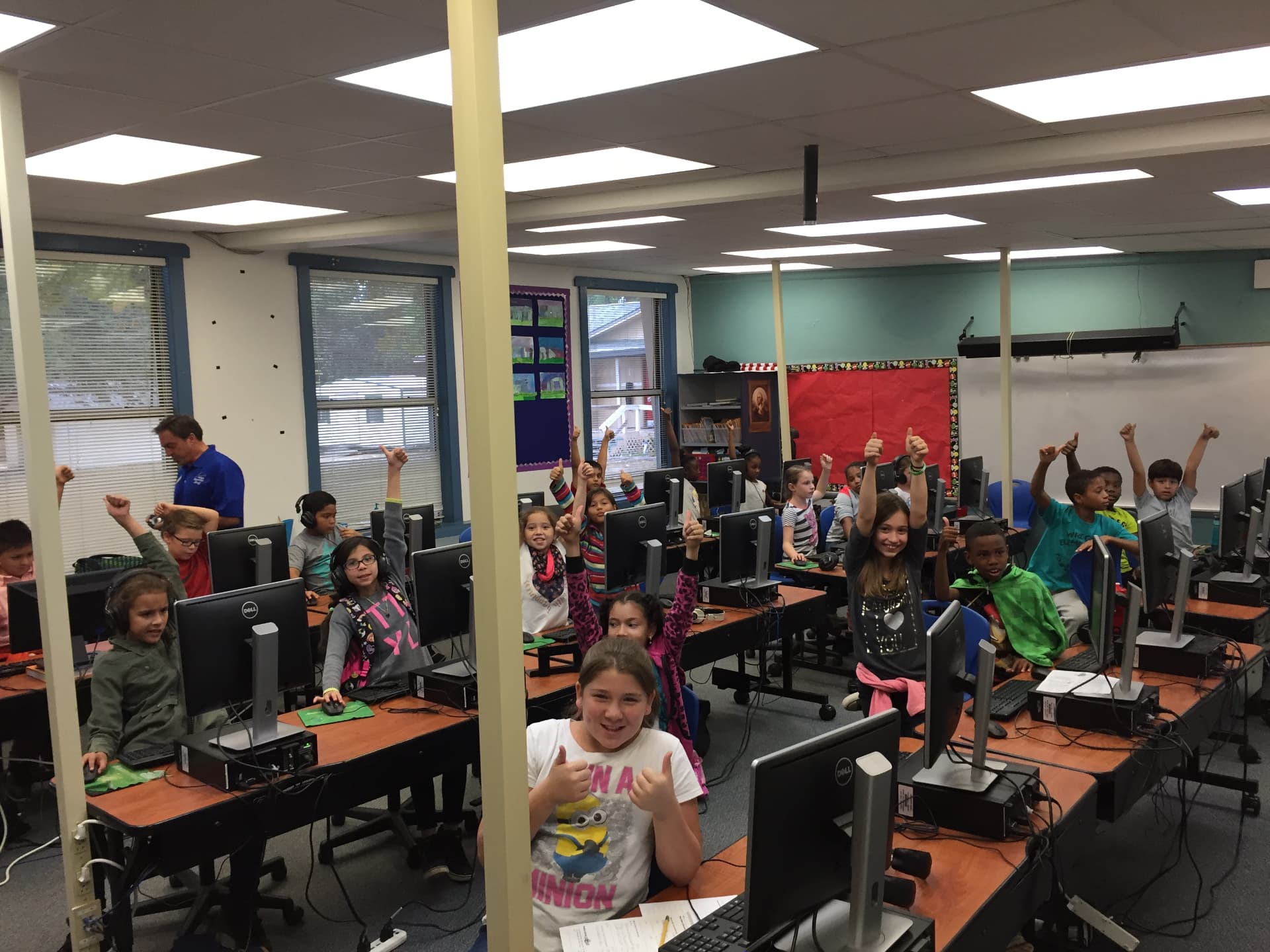 Elementary students giving a thumbs up in a computer lab
