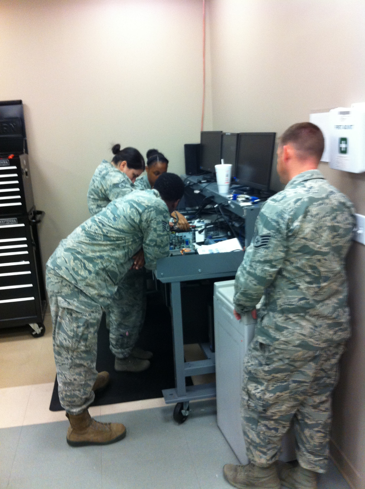 Airmen troubleshooting computer hardware together